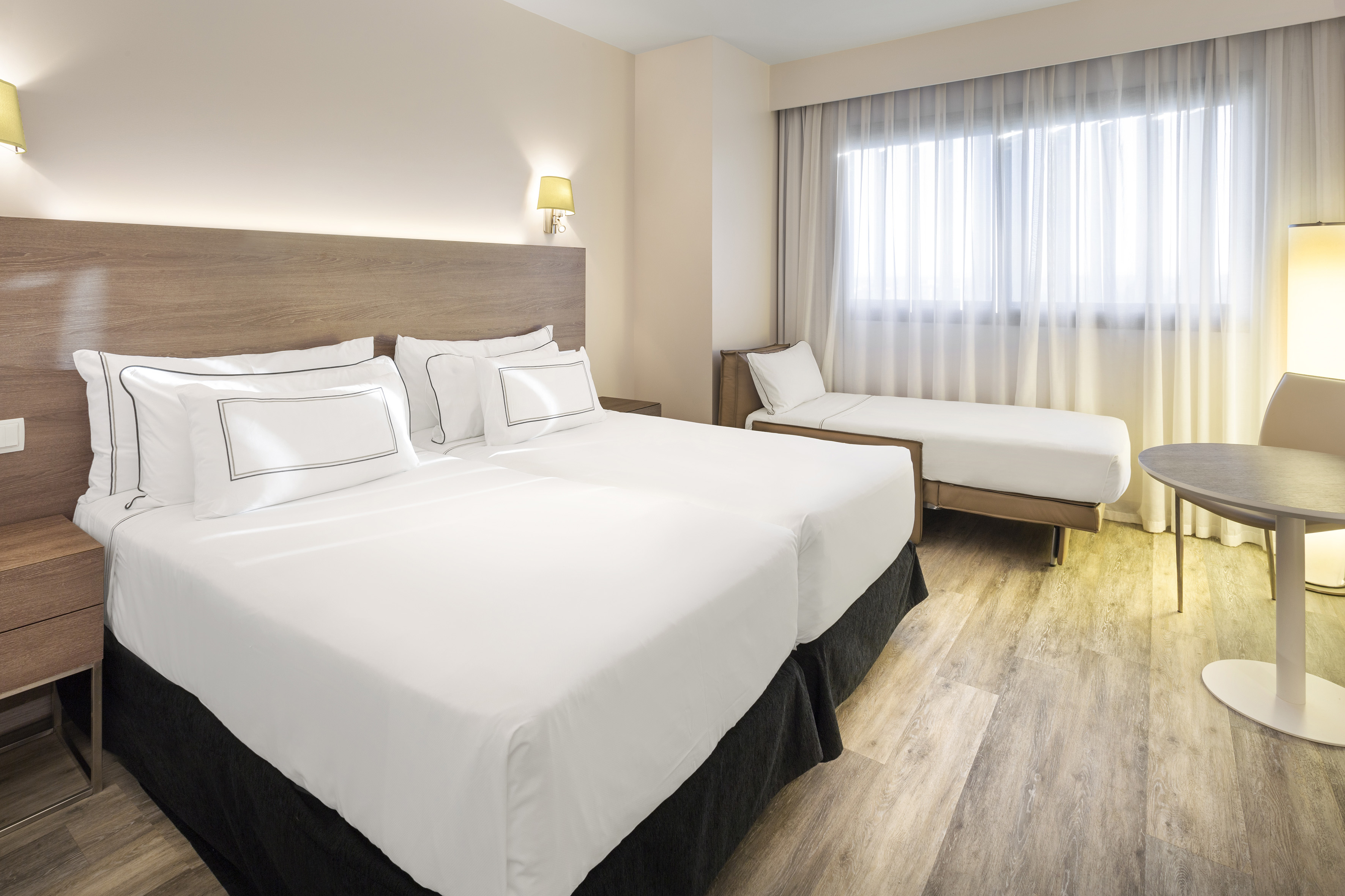 a room with two beds and a wood floor