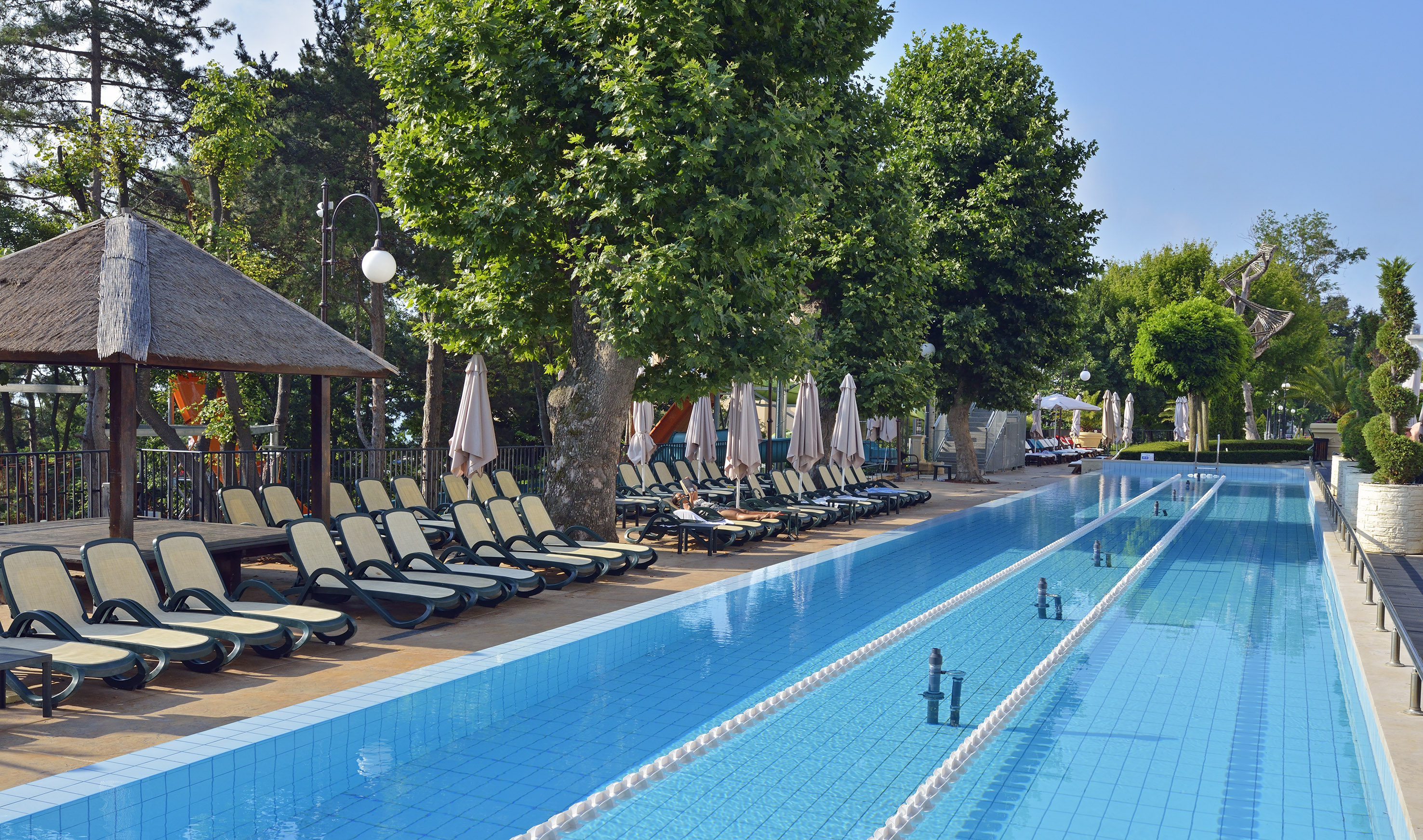 a pool with lounge chairs and umbrellas
