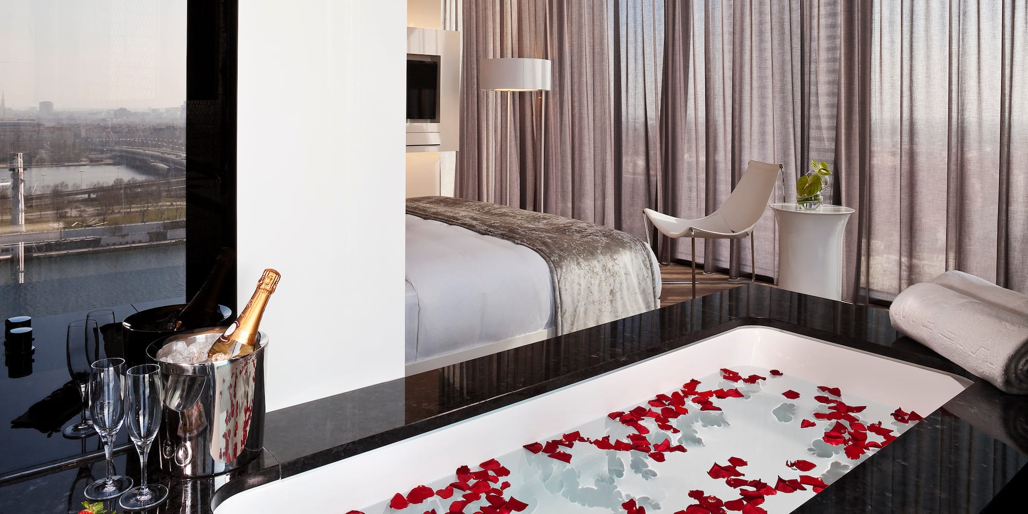 a bathtub with rose petals in a hotel room