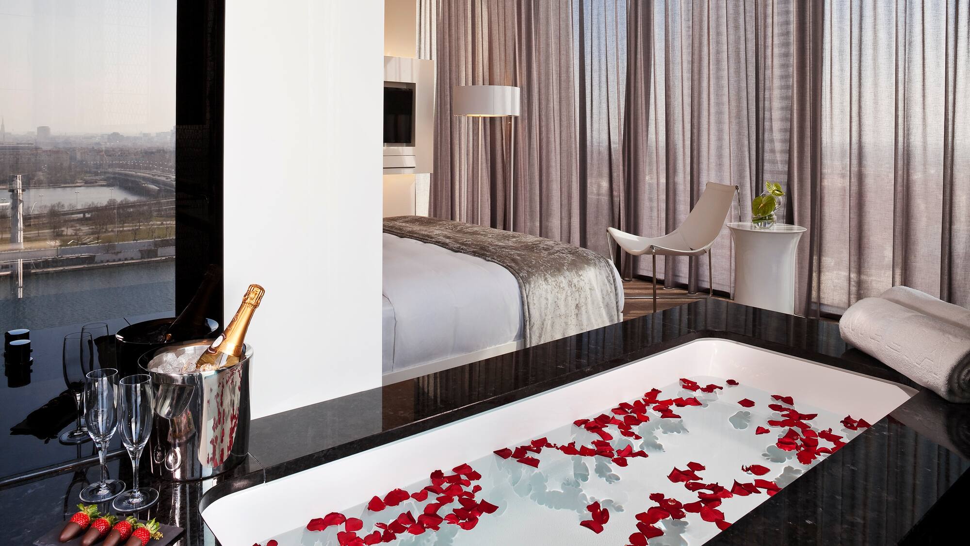 a bathtub with rose petals in a hotel room