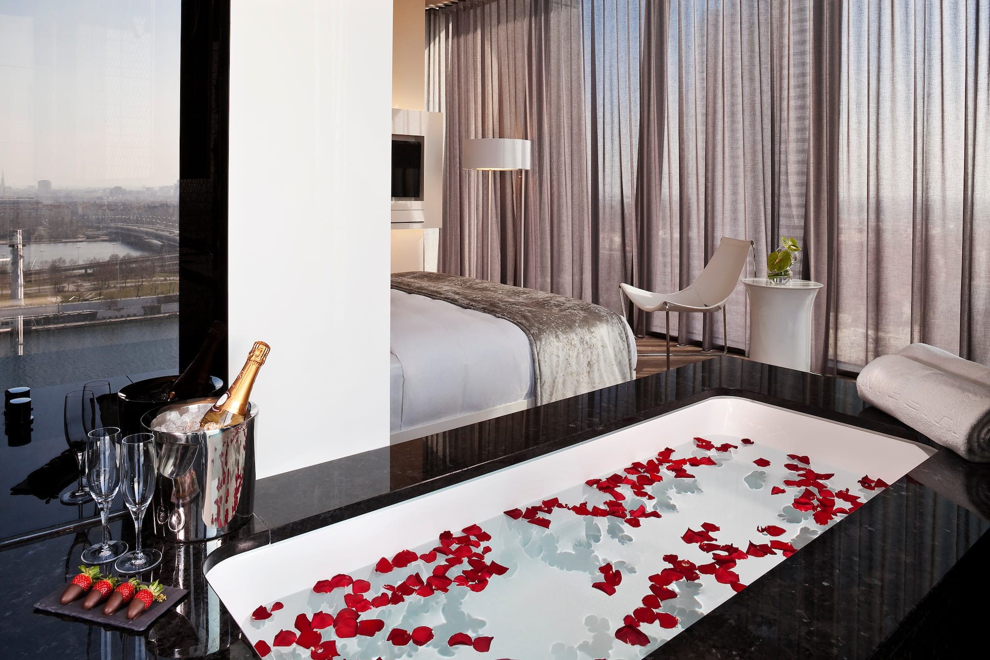 a bathtub with rose petals in a hotel room