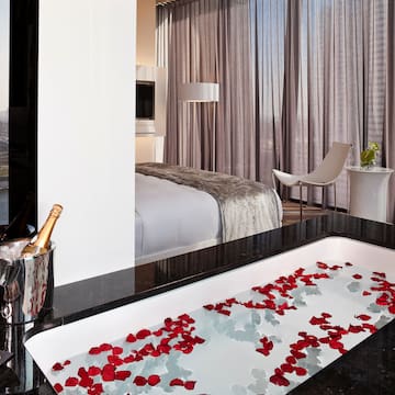 a bathtub with rose petals in a hotel room