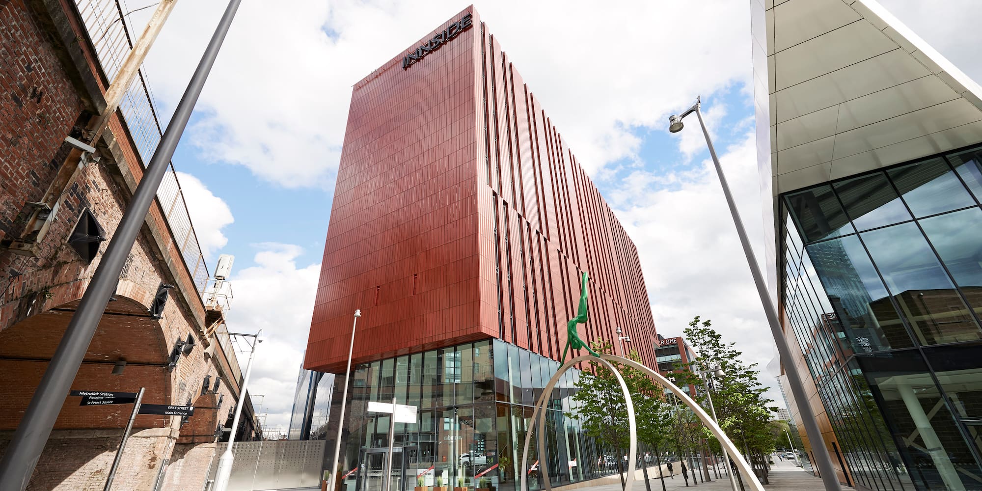 a building with a glass wall and a tree in front of it