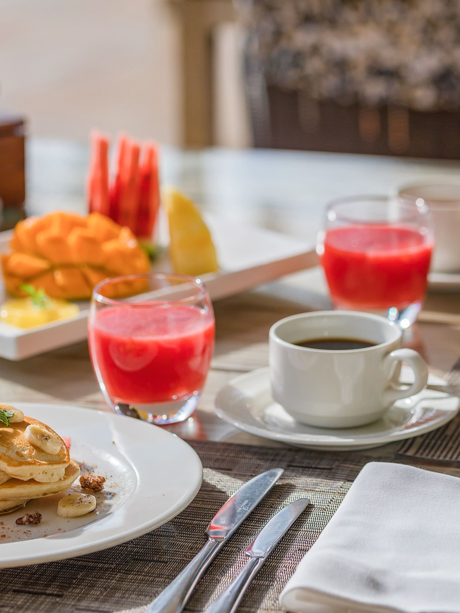 a plate of pancakes and fruit on a table