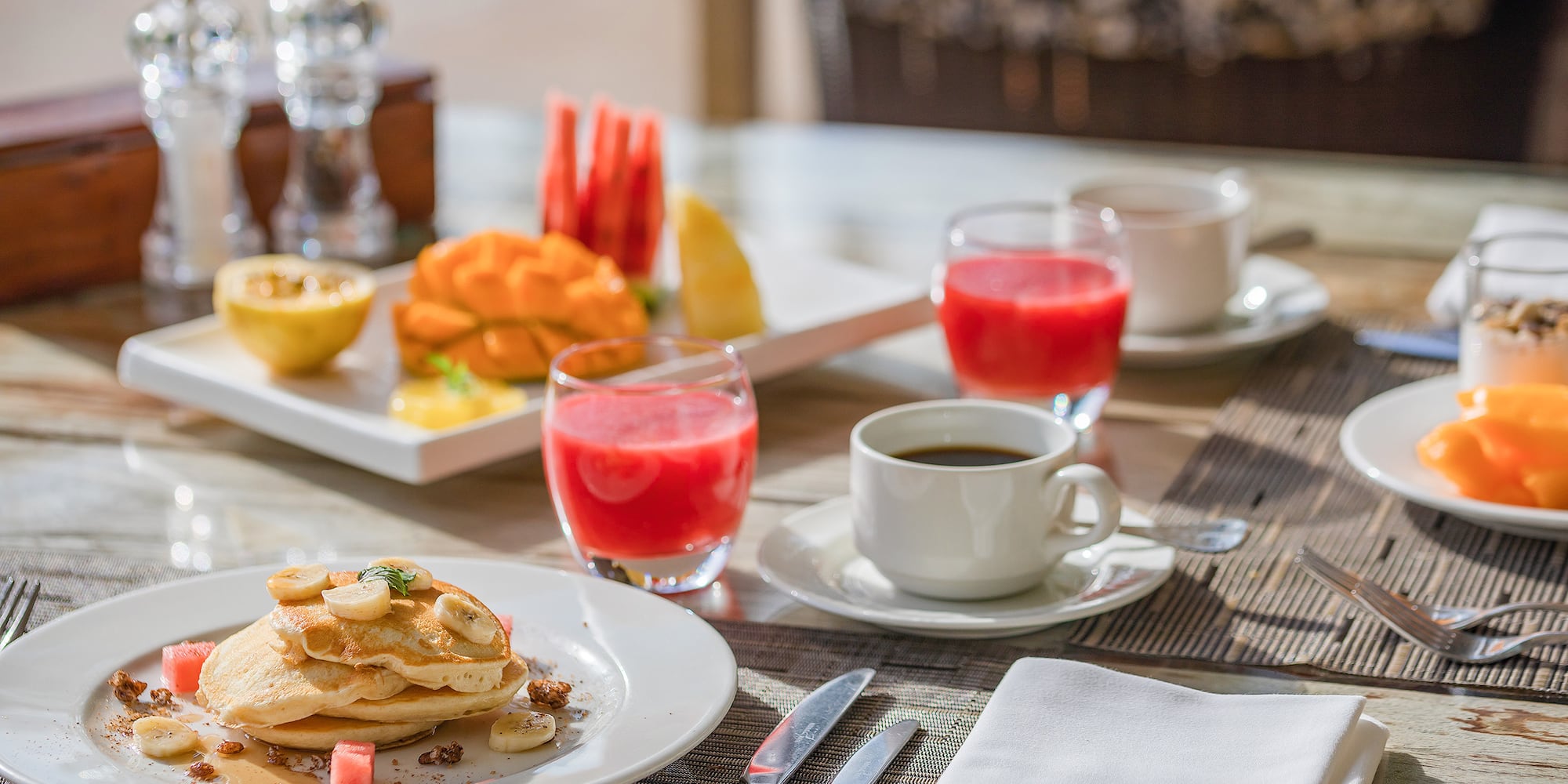 a plate of pancakes and fruit on a table