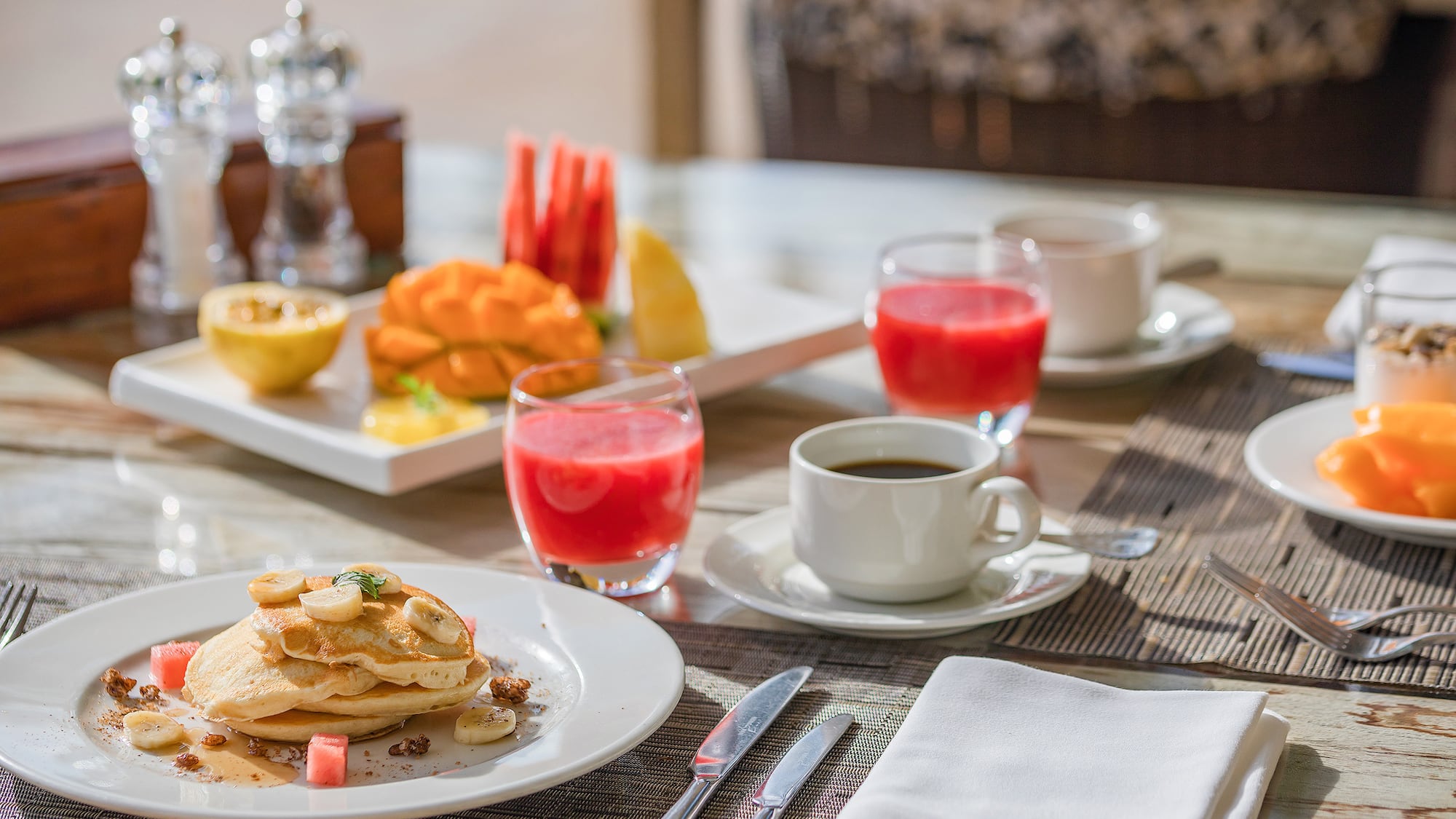 a plate of pancakes and fruit on a table