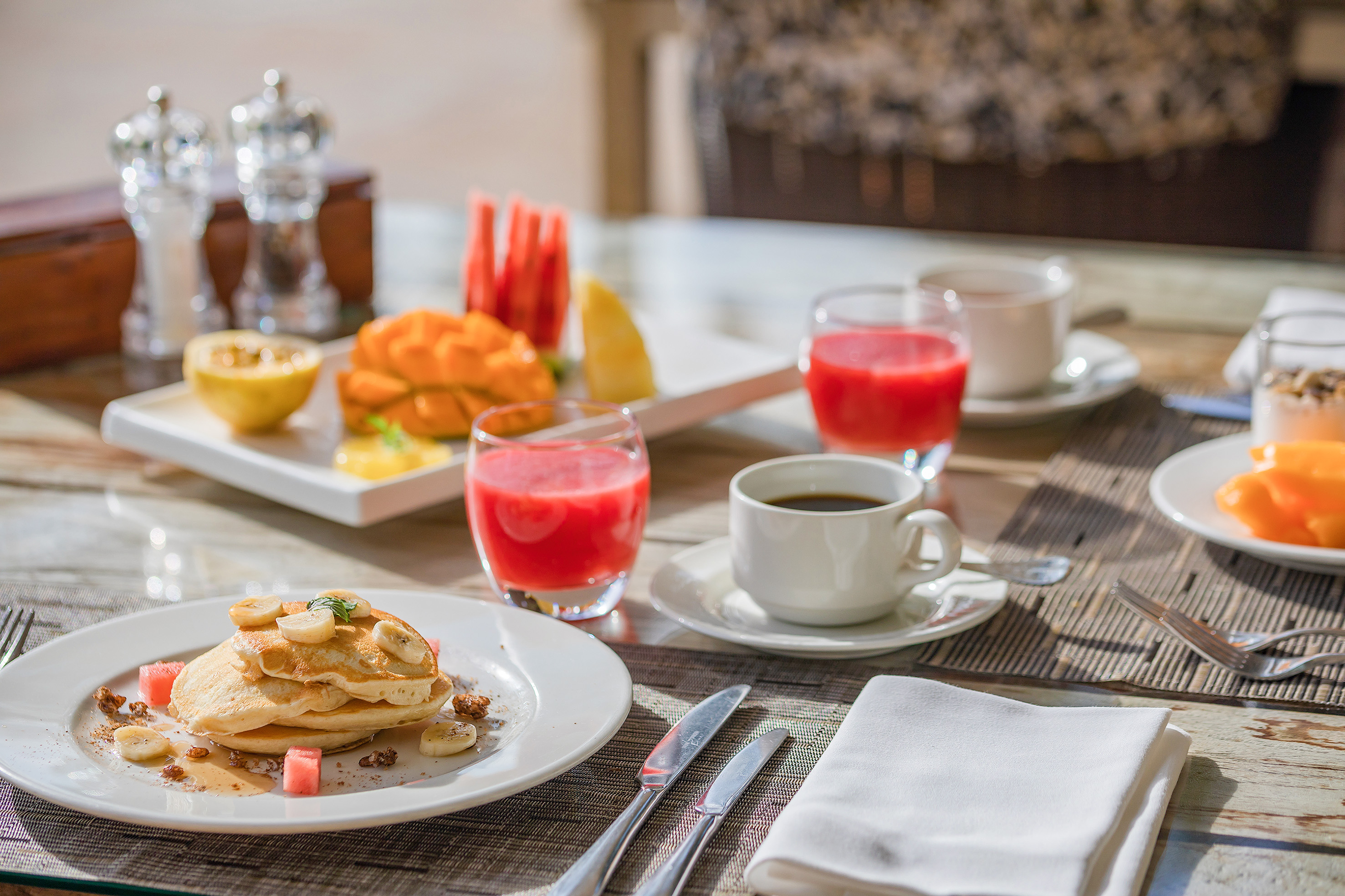 a plate of pancakes and fruit on a table