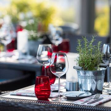 a table with wine glasses and a potted plant