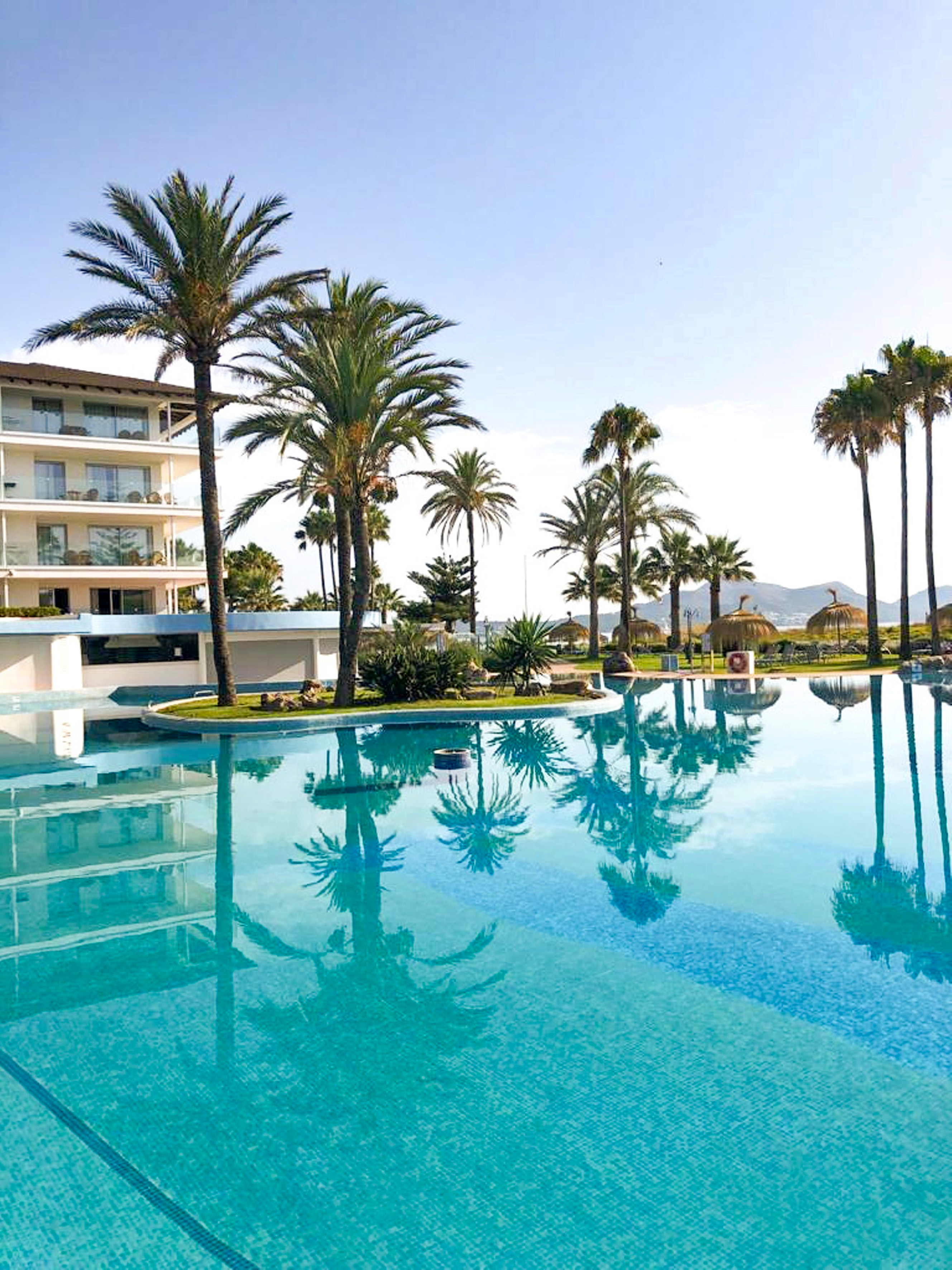 a pool with palm trees and buildings