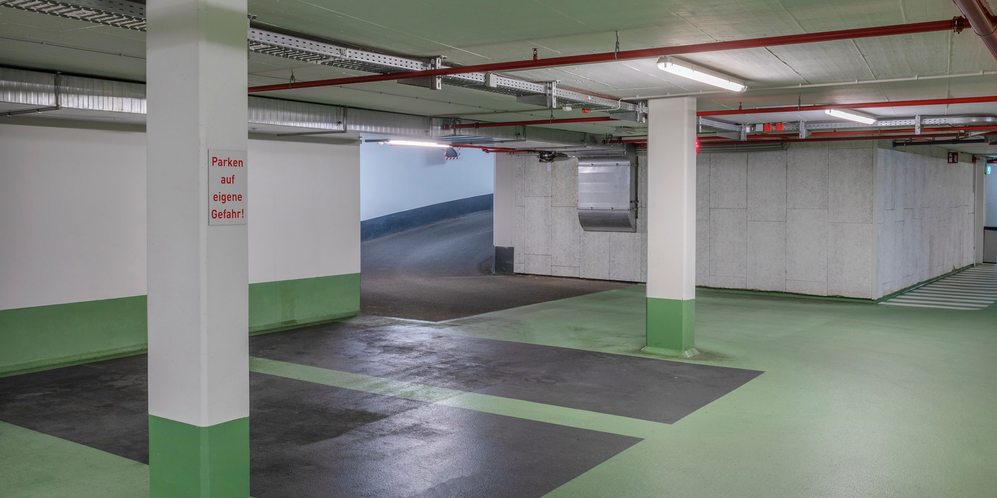 a parking garage with white pillars and green floor