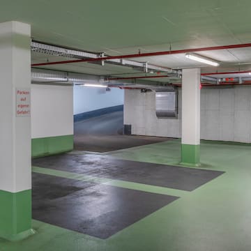 a parking garage with white pillars and green floor