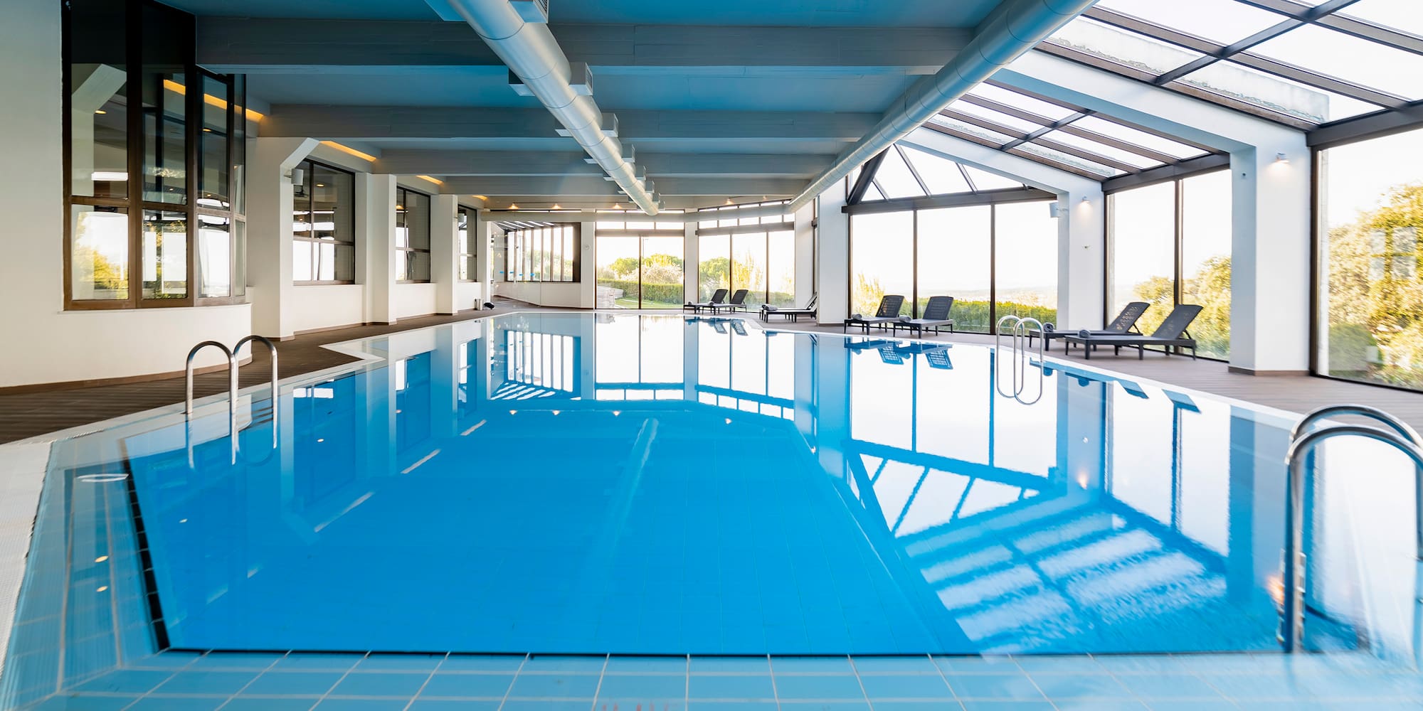 a indoor pool with chairs and a large window