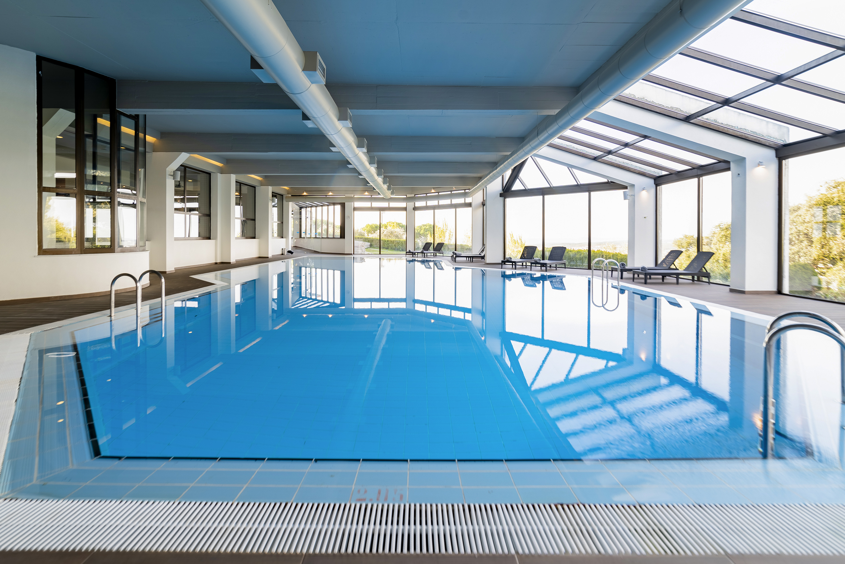 a indoor pool with chairs and a large window