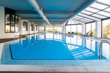 a indoor pool with chairs and a large window