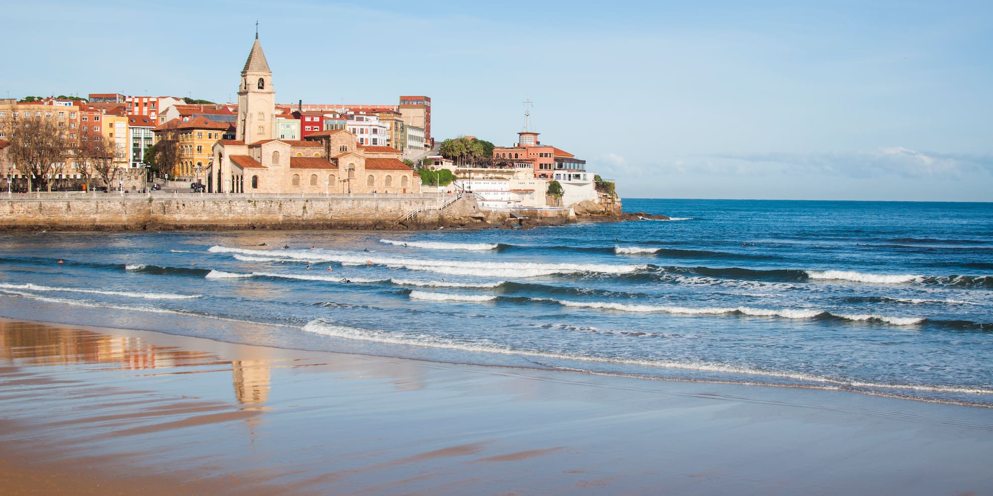a beach with buildings and waves