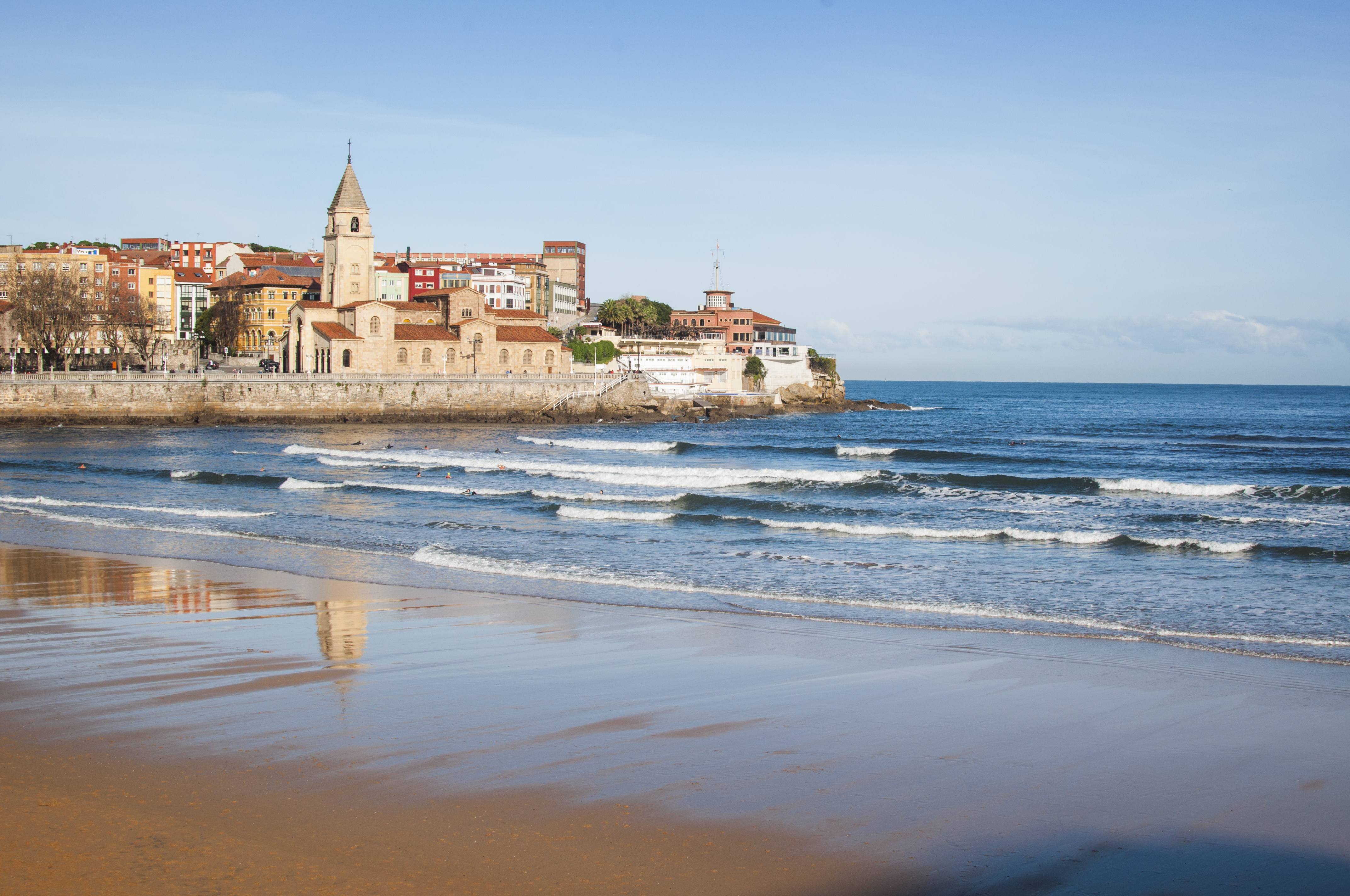 a beach with buildings and waves
