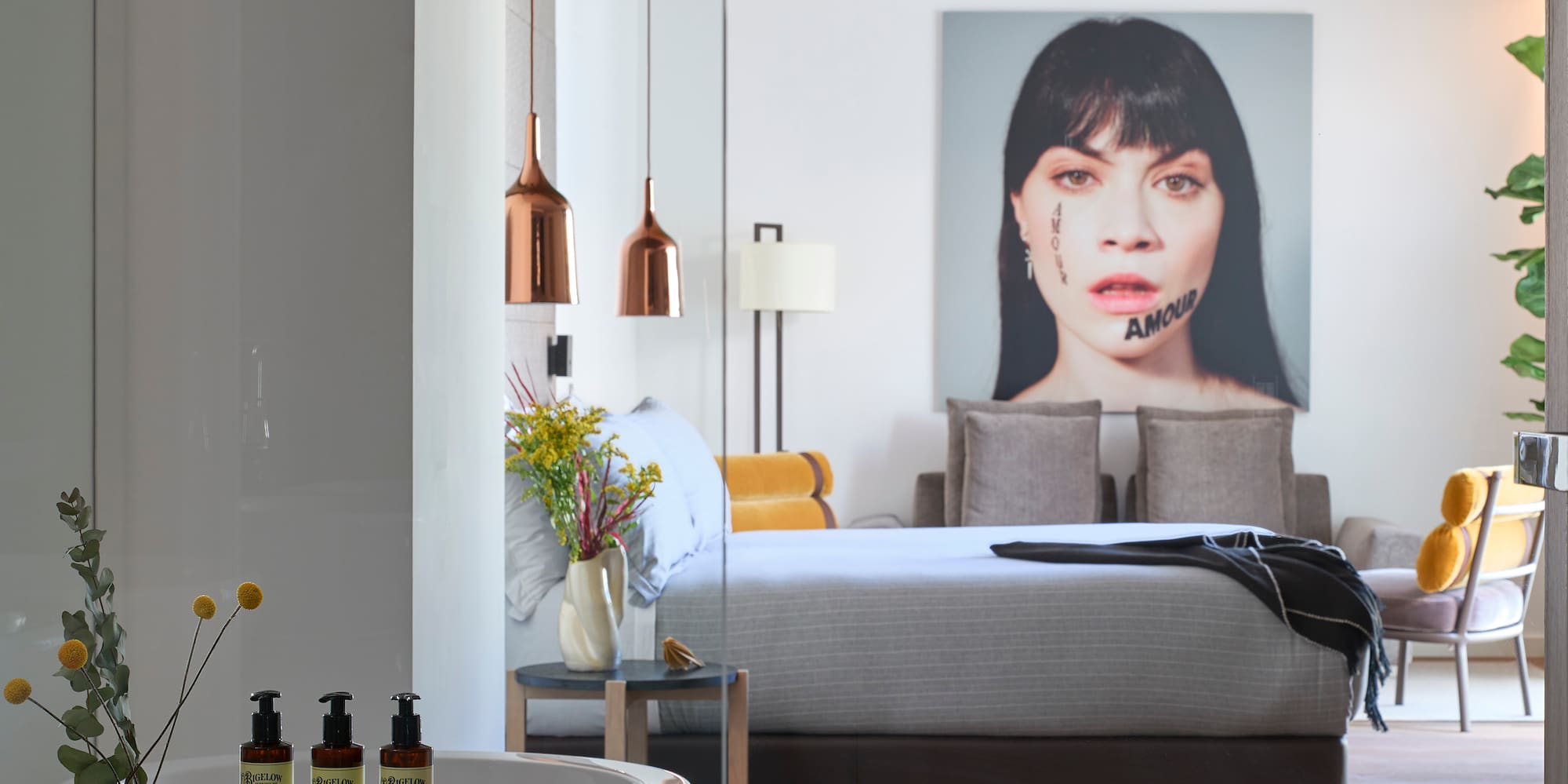 a bedroom with a bed and a picture of a woman