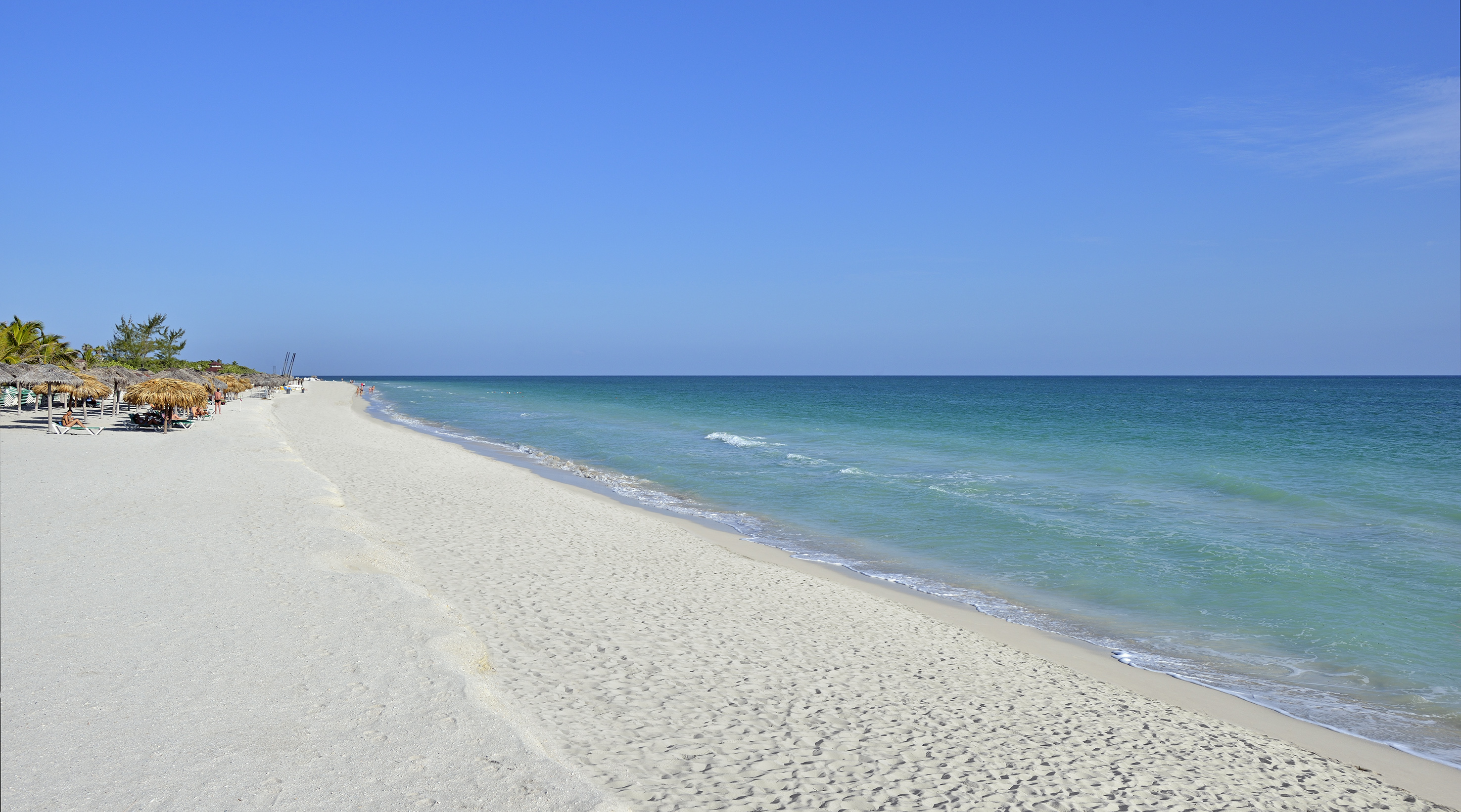 a beach with blue water and blue sky