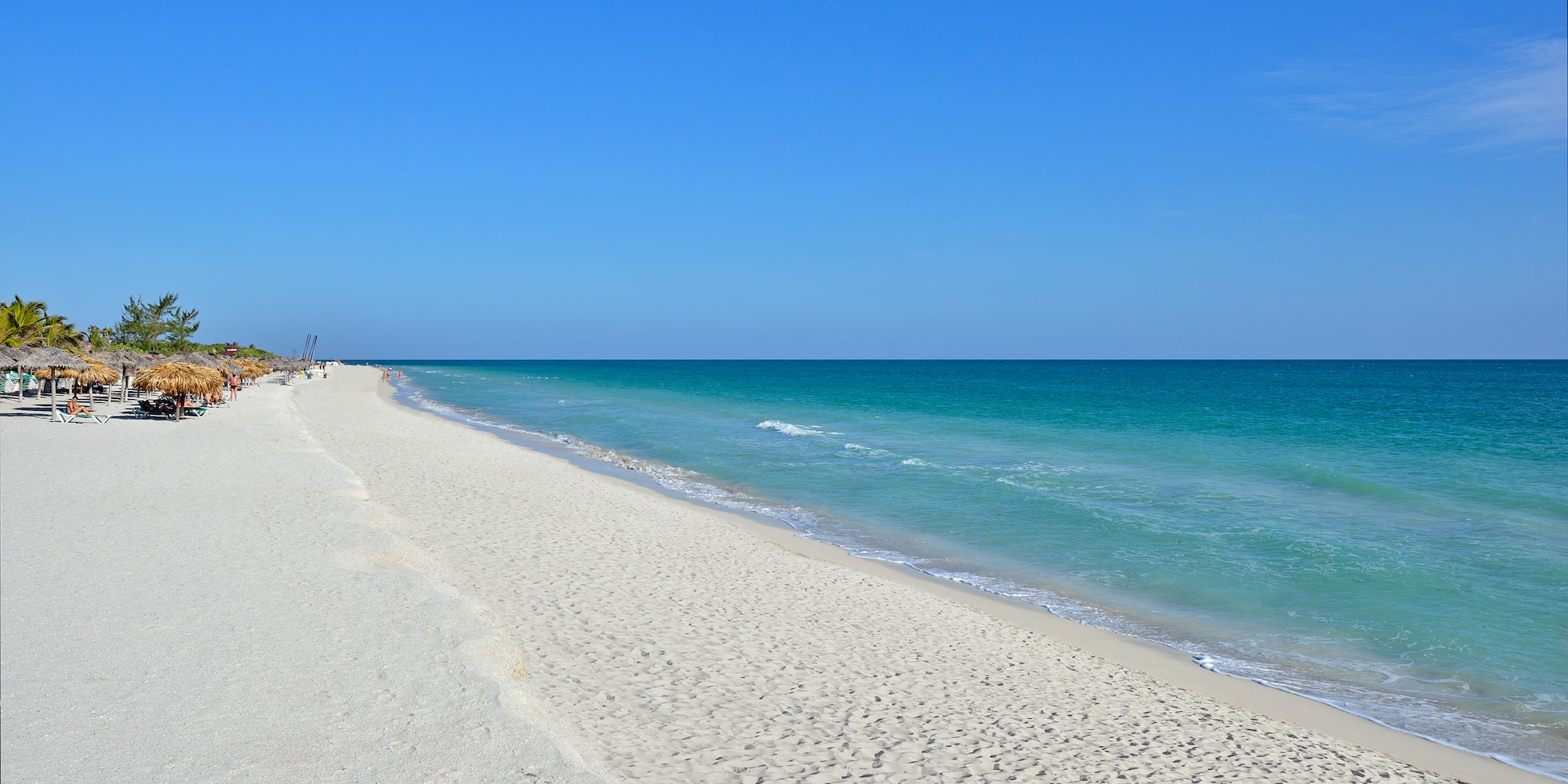 a beach with blue water and blue sky