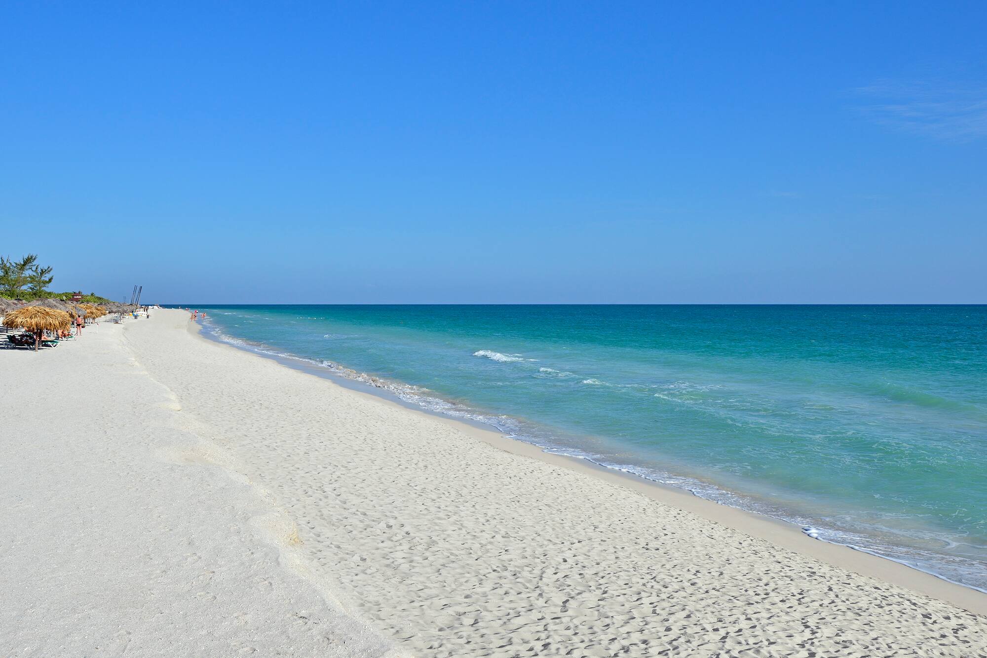 a beach with blue water and blue sky