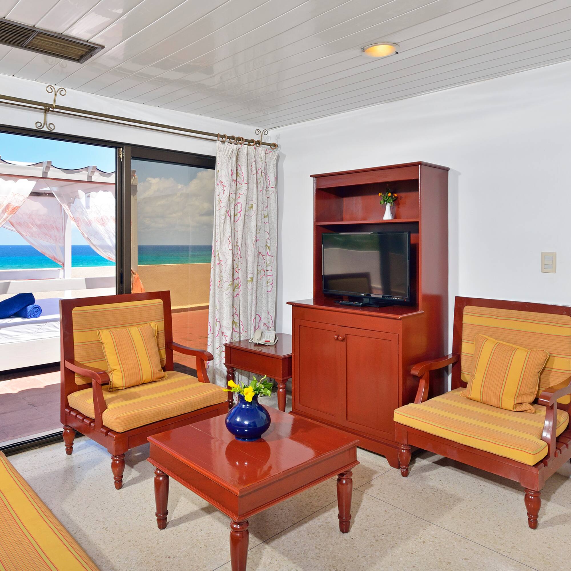 a living room with a television and chairs