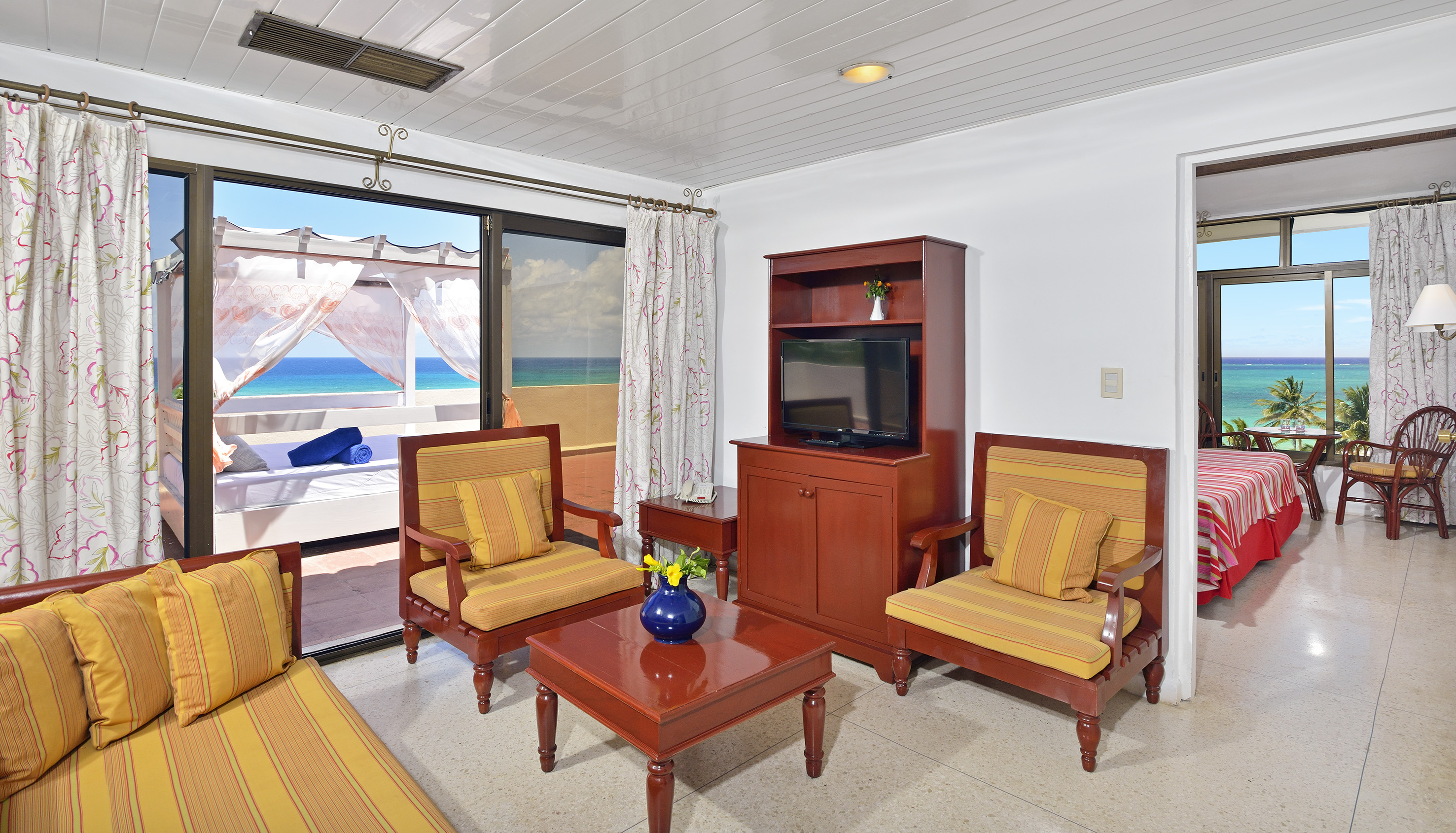 a living room with a television and chairs