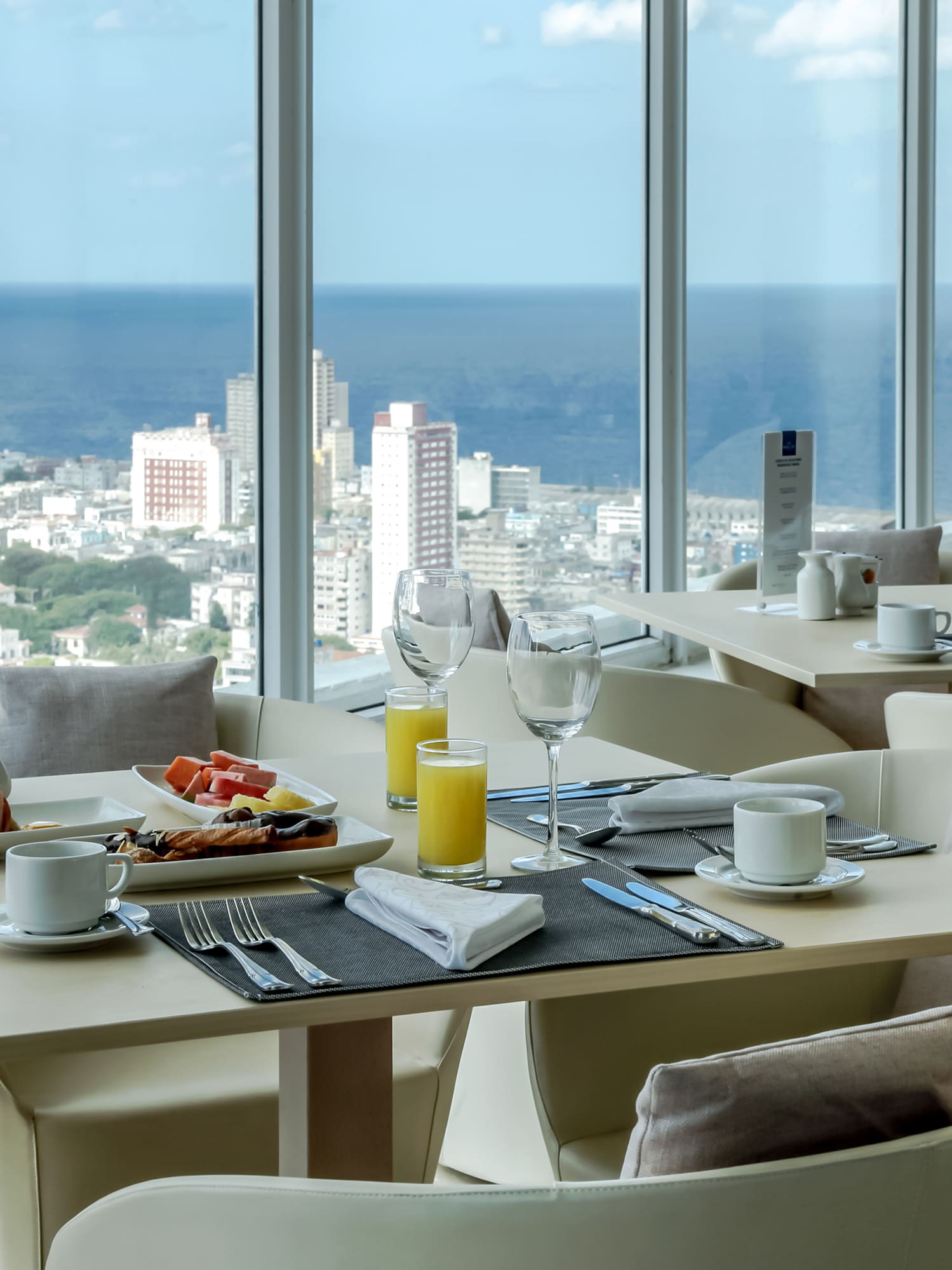 a table with food and drinks in a room with large windows
