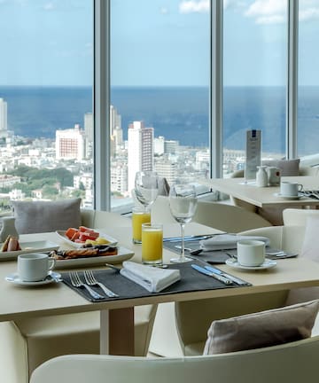 a table with food and drinks in a room with large windows