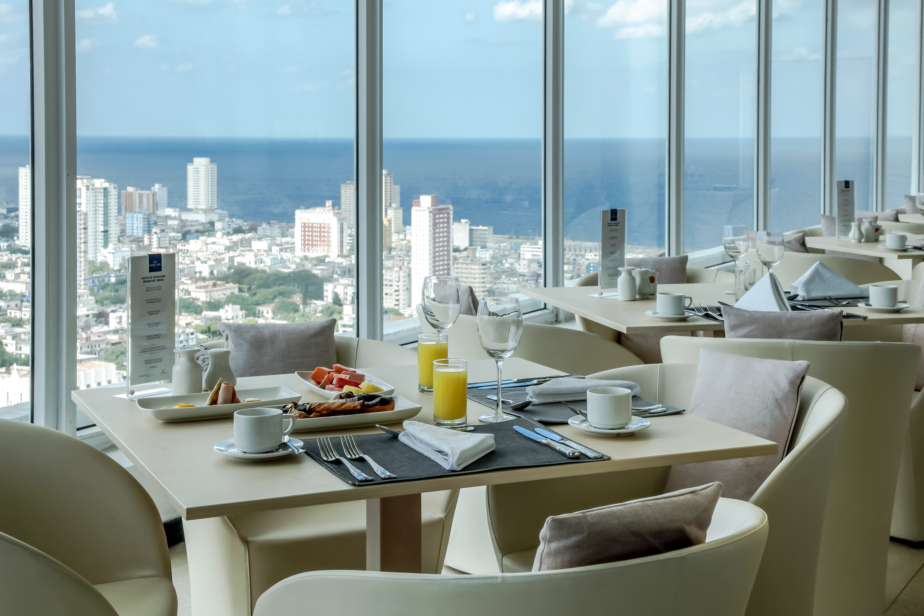 a table with food and drinks in a room with large windows