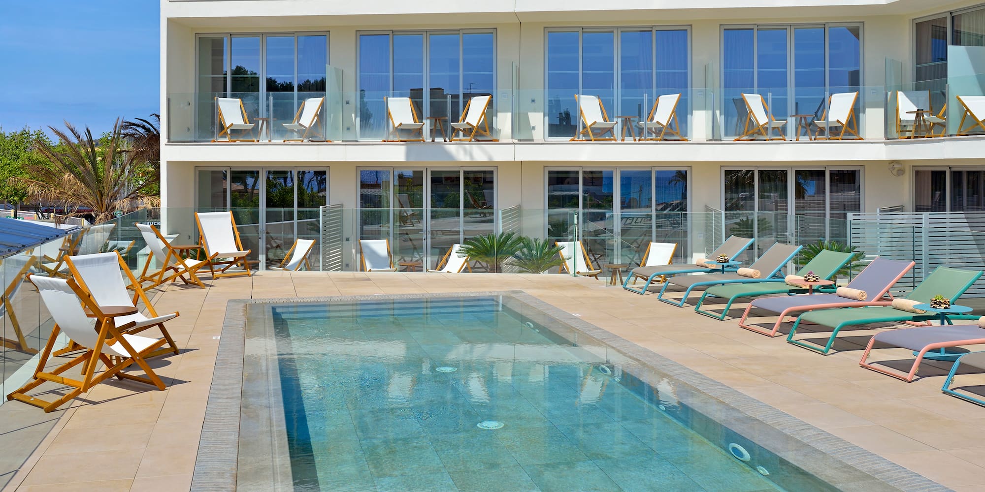 a woman lying on a deck chair next to a pool