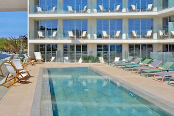 a woman lying on a deck chair next to a pool