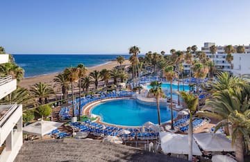 a pool with palm trees and a beach