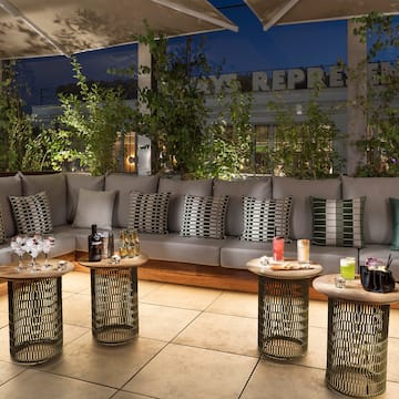 a patio with a couch and tables with drinks