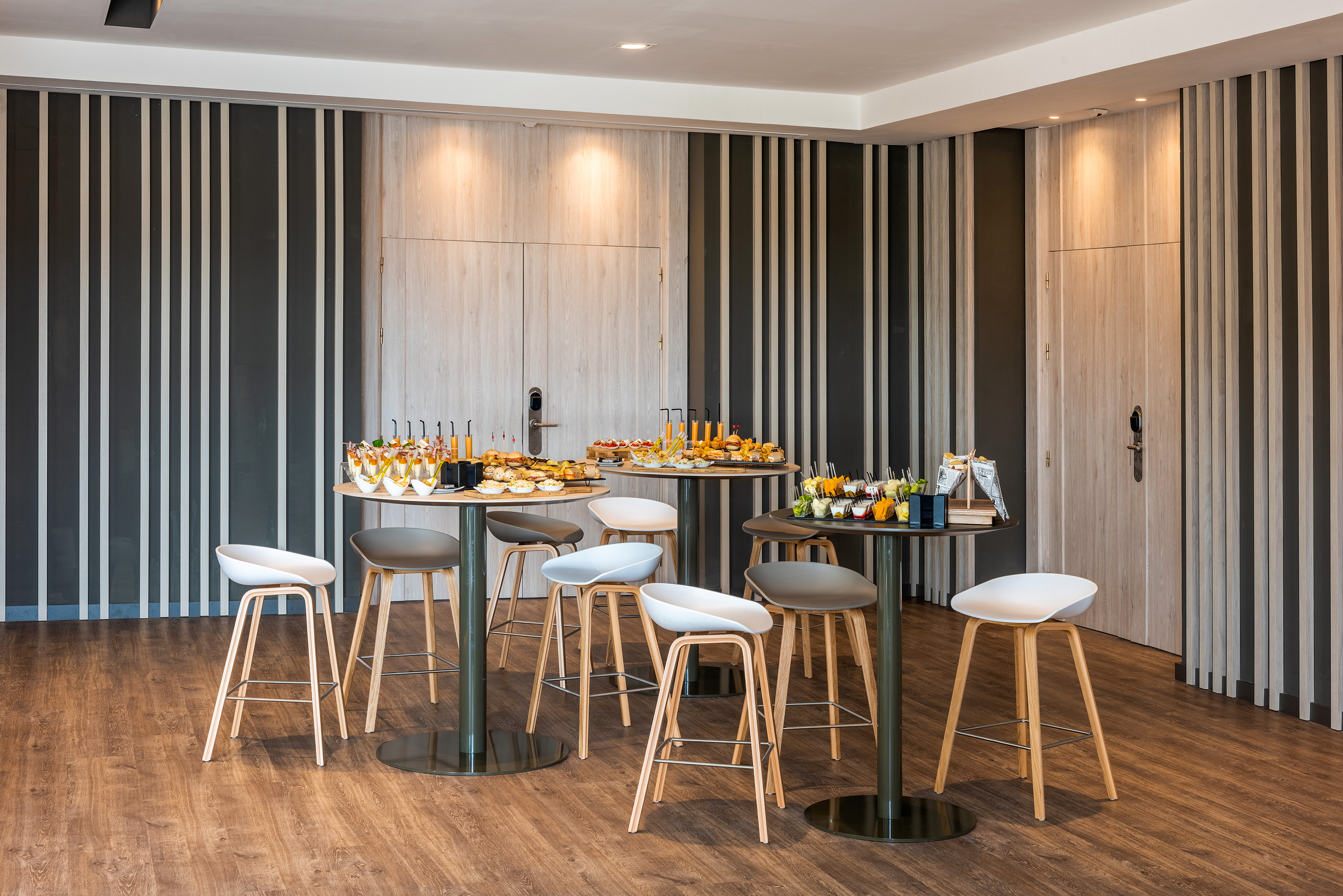 Stylish modern event space with buffet food, drinks, and bar stools.