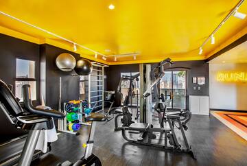 a room with exercise equipment and a yellow ceiling