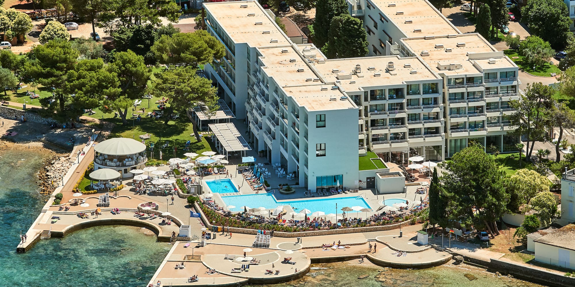 a building with a pool and people around it