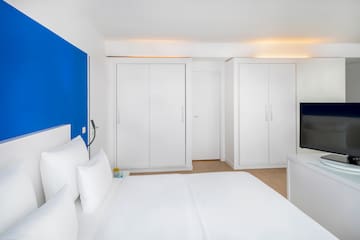a bedroom with white furniture and a blue wall