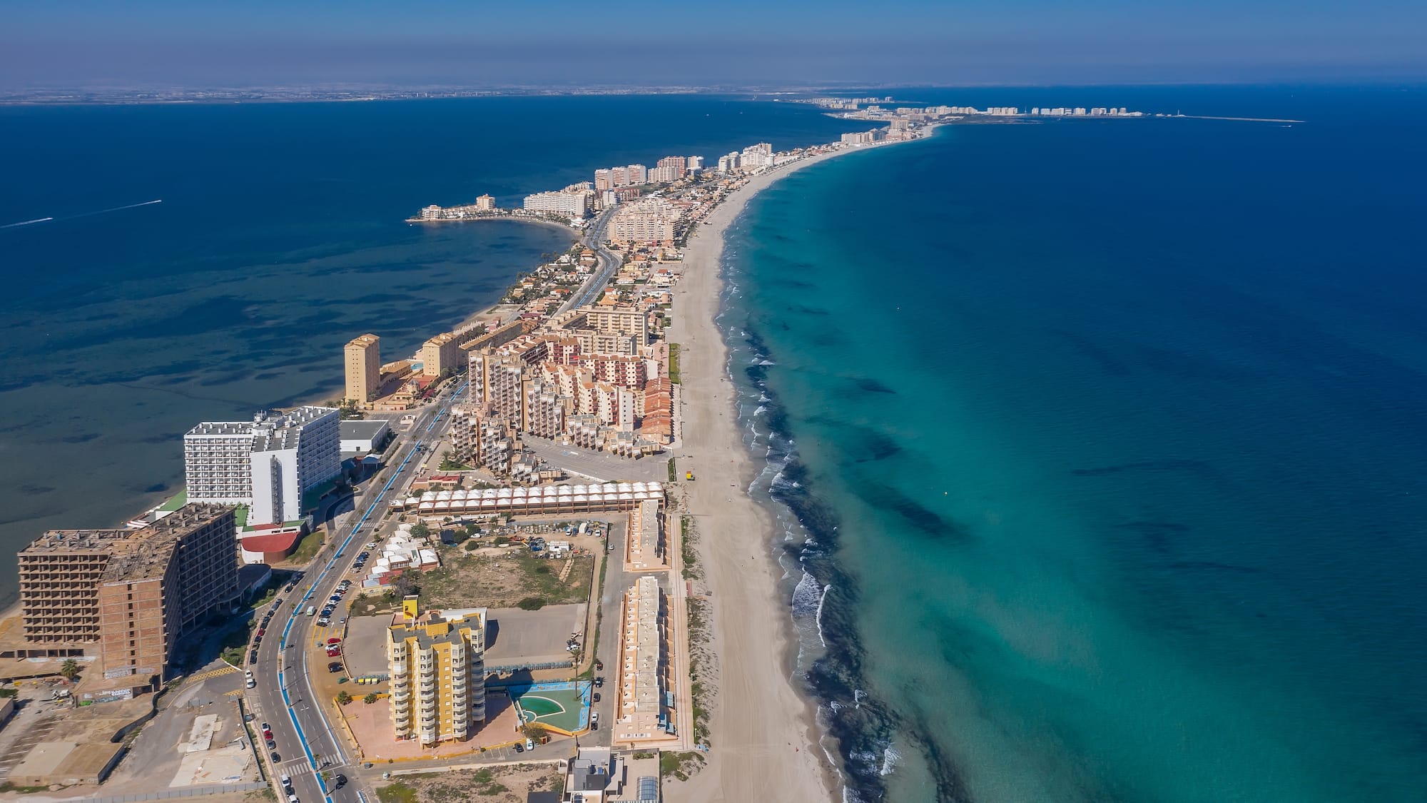 a beach with buildings and a body of water