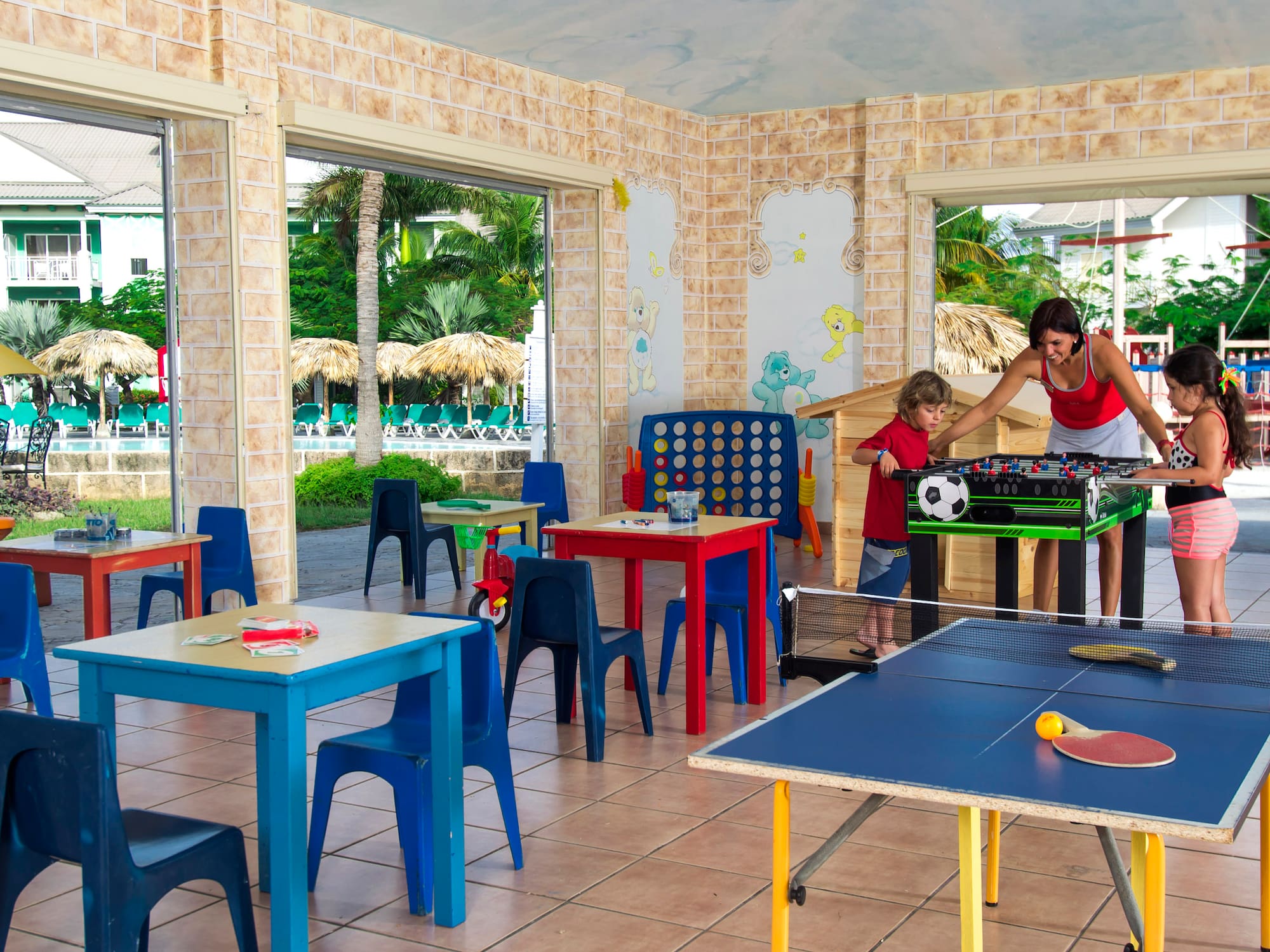 a woman and two children playing table tennis