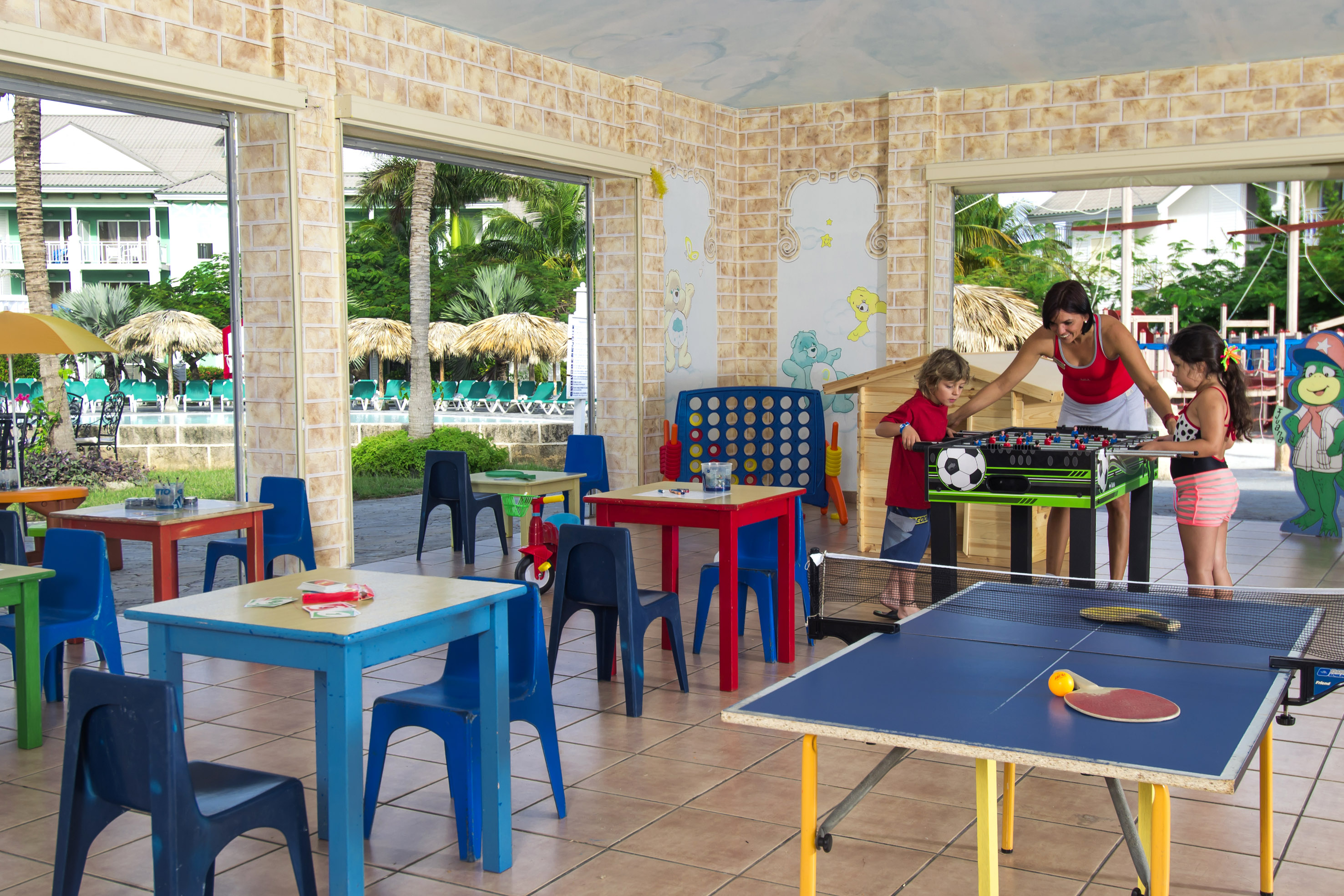 a woman and two children playing table tennis