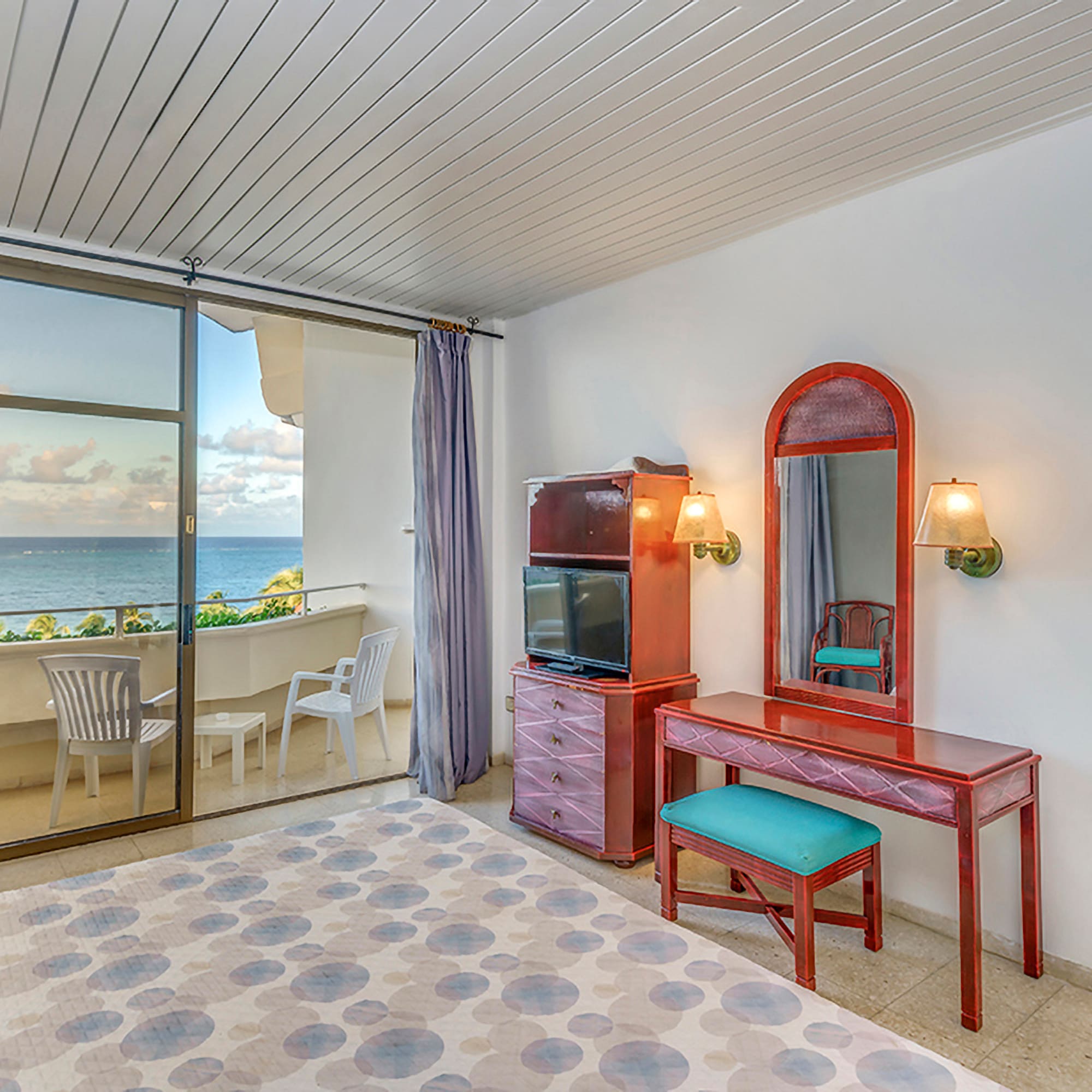 a room with a mirror and dresser