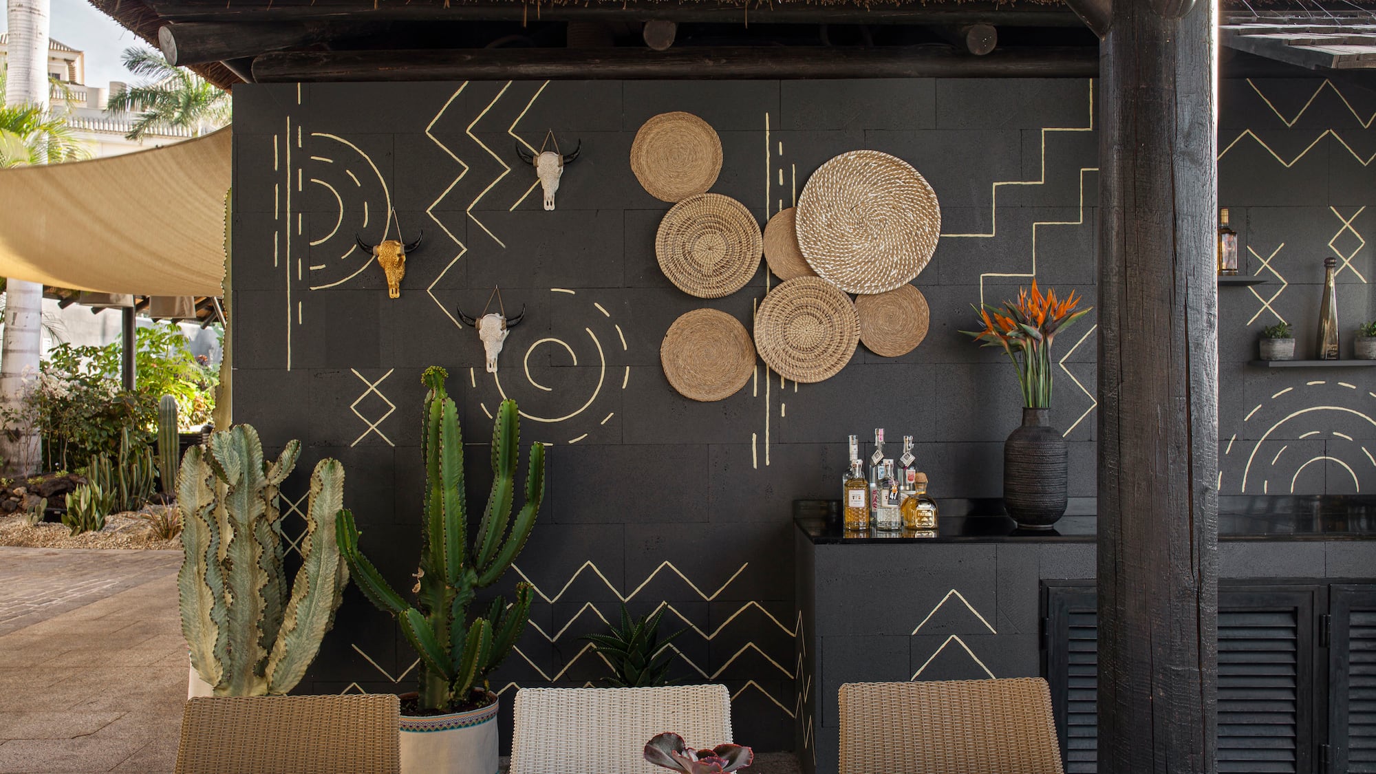 a table set up with a wall of plants and a wall of glass