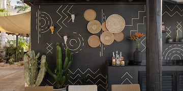 a table set up with a wall of plants and a wall of glass