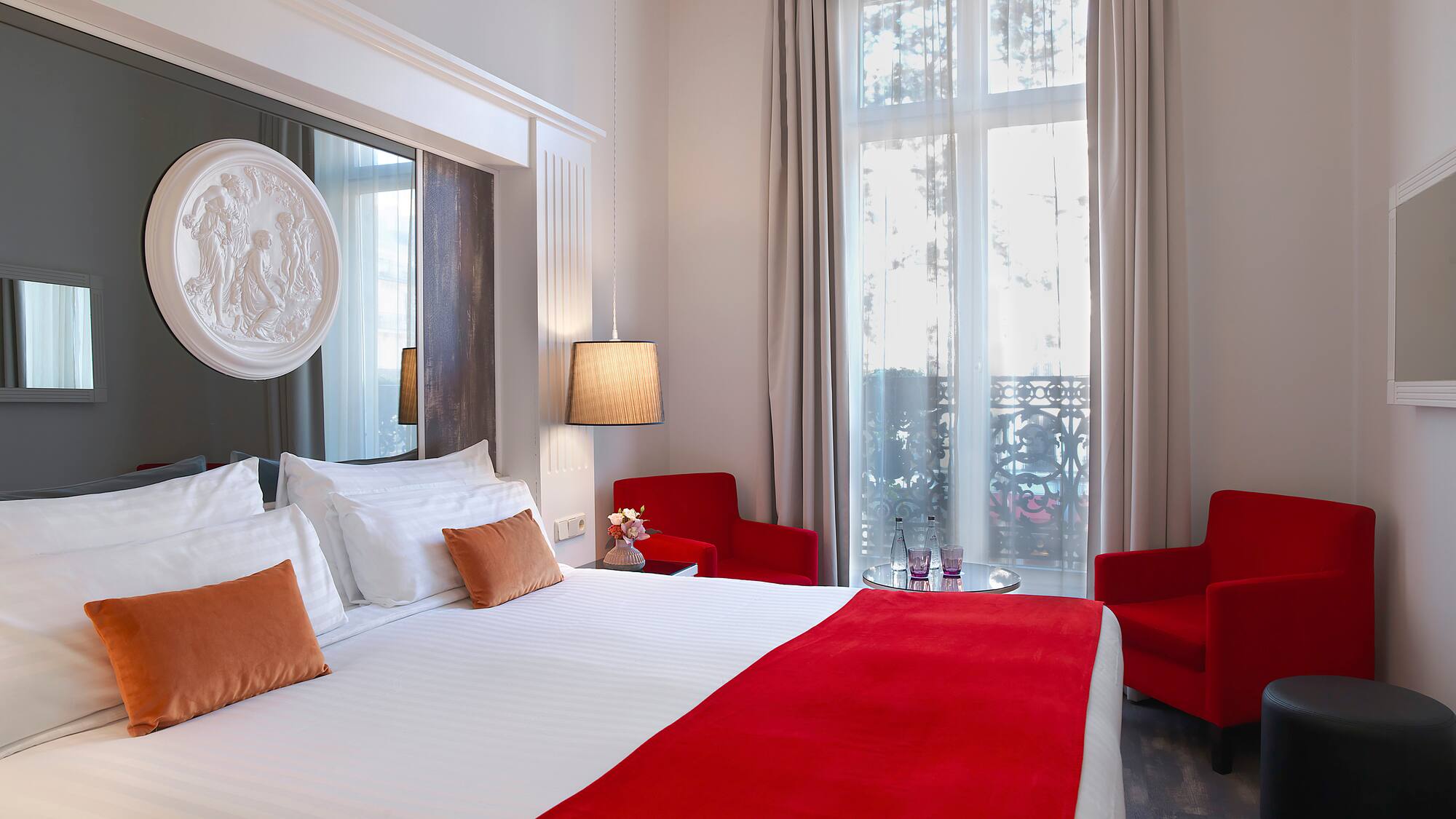 a room with a bed and chairs