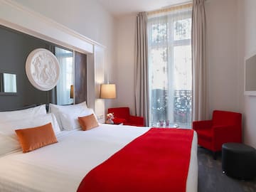 a room with a bed and chairs