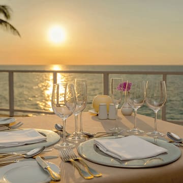 a table set for a dinner with a view of the ocean