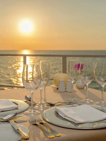 a table set for a dinner with a view of the ocean