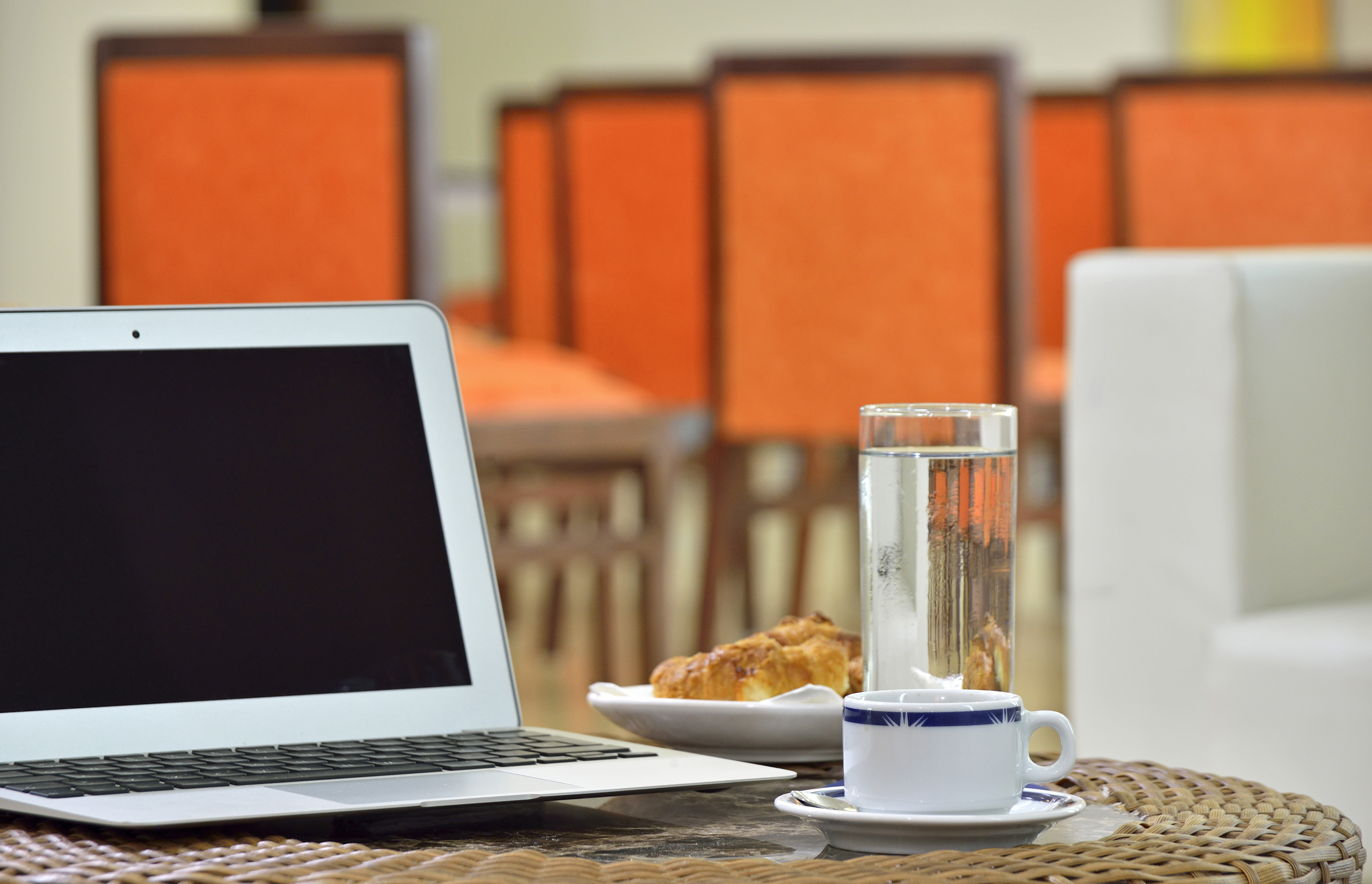 a laptop and a cup of water on a table