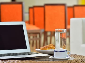 a laptop and a cup of water on a table