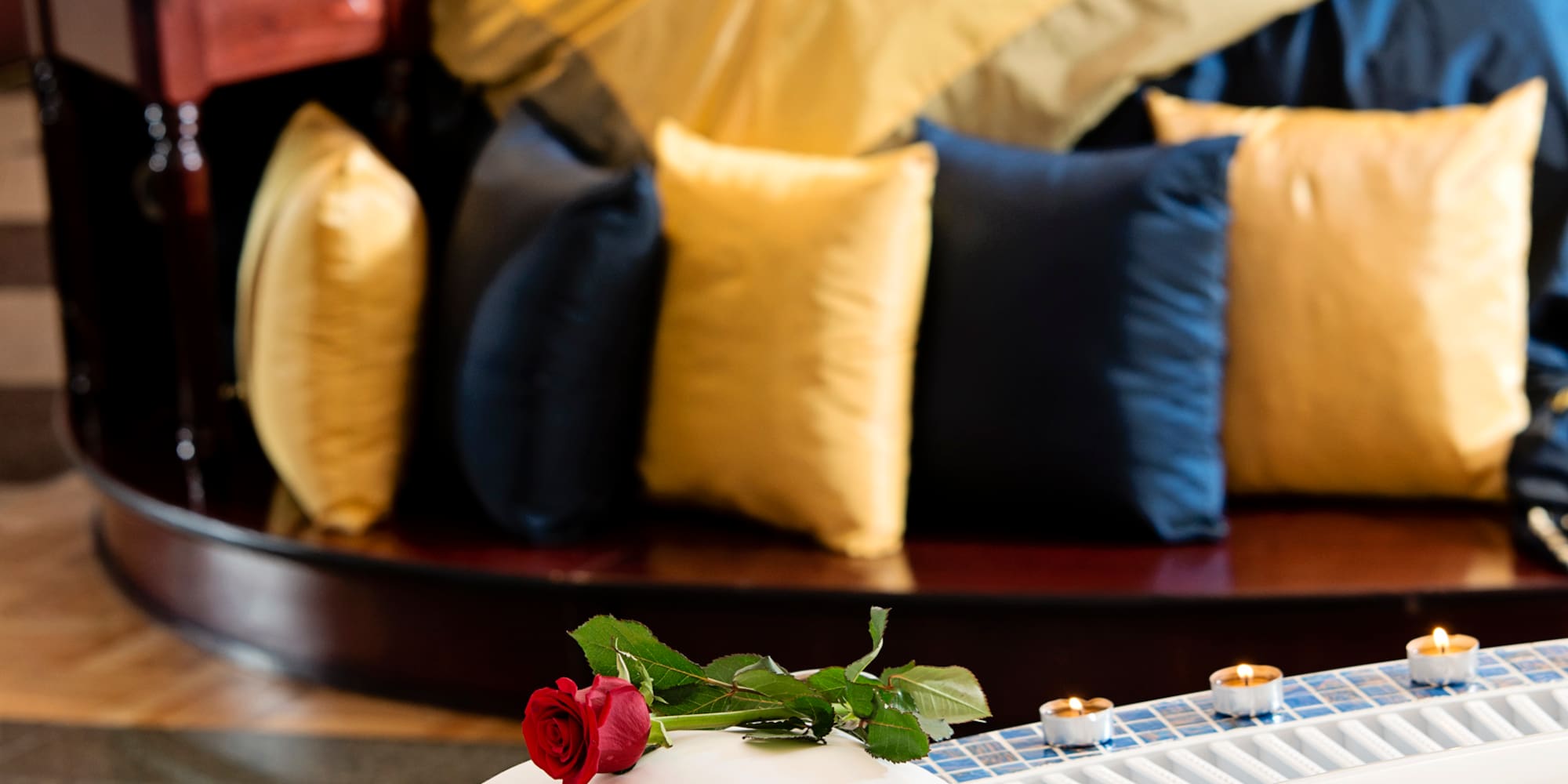 a rose on a pillow on a bathtub